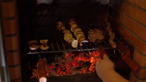 woman removing skewered meat from grill