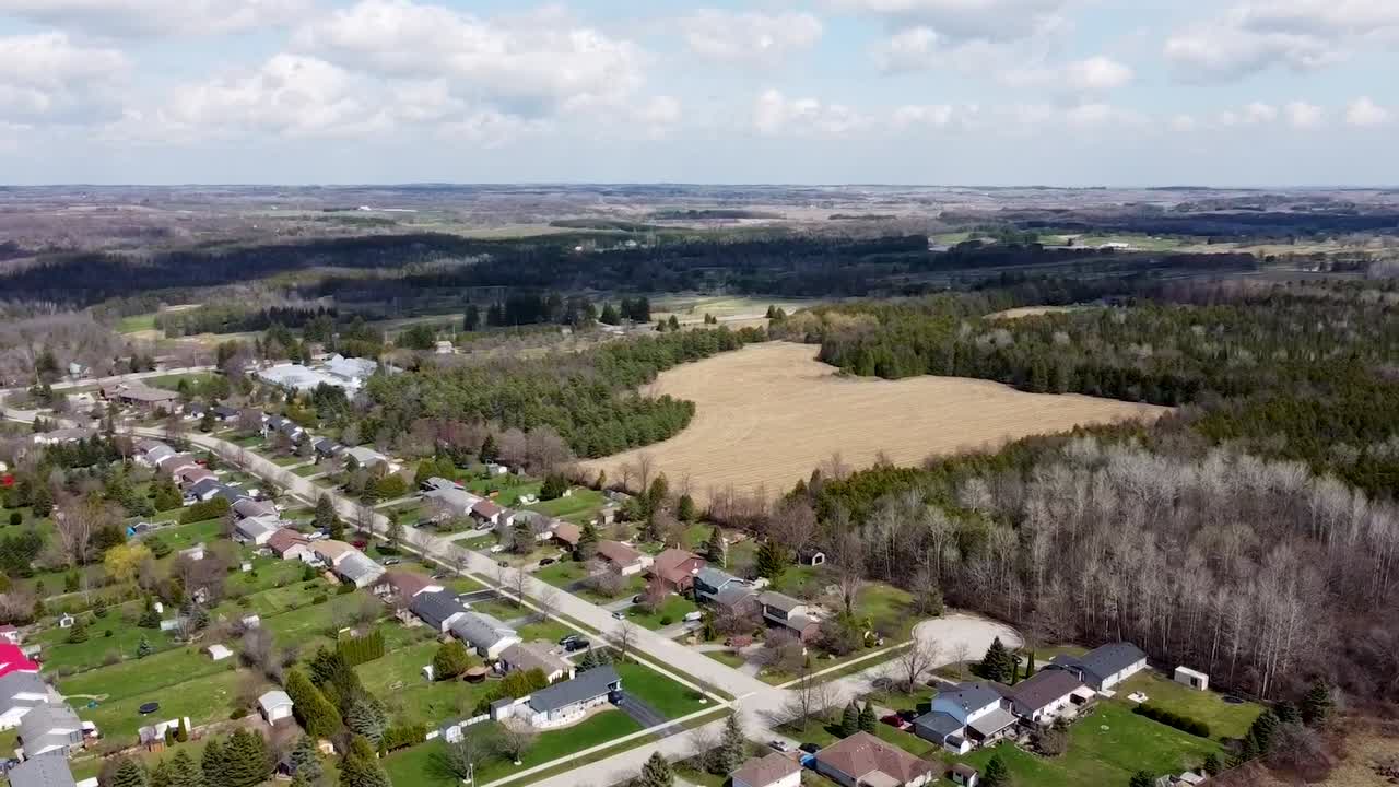 Udsigt fra en drone af et solrigt kvarter nær marker lige uden for Toronto.
