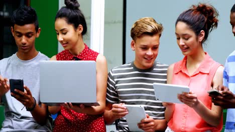 estudiantes que utilizan portátiles, teléfonos móviles y tabletas digitales