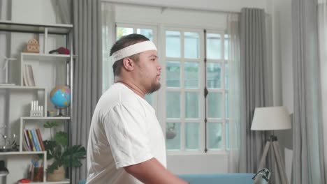 asian fat man training on walking treadmill at home
