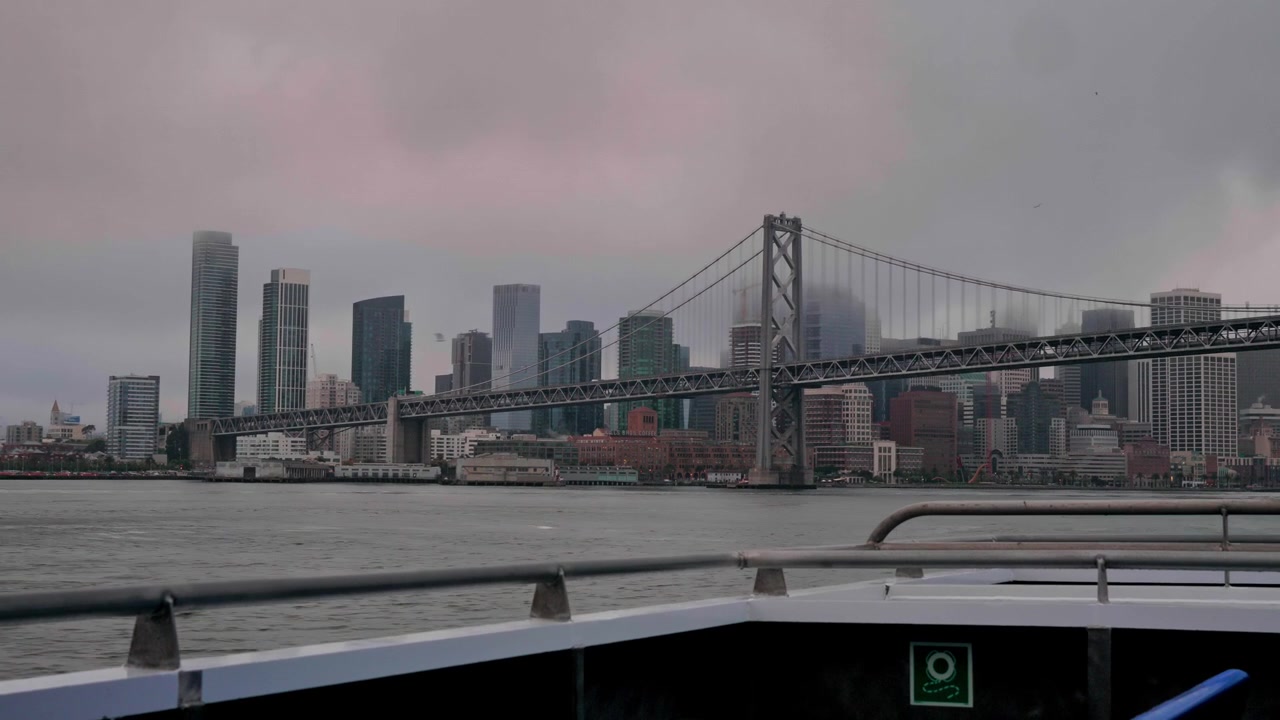 Un ferry se desliza por la bahía, ofreciendo una vista impresionante del Puente de la Bahía arqueándose elegantemente sobre las aguas de San Francisco, California, Estados Unidos