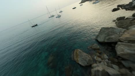 Fpv-Drone-Tiro-En-Movimiento-Hacia-Adelante-Volando-Sobre-Veleros-Atracados-A-Lo-Largo-De-La-Playa-En-La-Playa-De-Cala-D&#39;egos,-Mallorca,-España-Durante-La-Noche