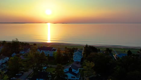 Sunset-over-Beach-House-in-Saco-Maine-with-Colors-Reflecting-off-Ocean-Waves-and-Vacation-Homes-Along-the-New-England-Atlantic-Coastline