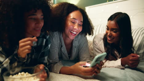 friends watching a movie on a smartphone at night