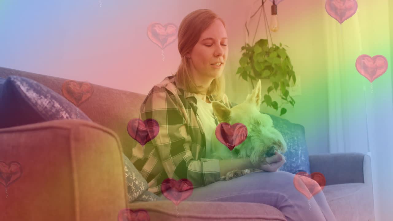 animación de emojis de corazón y bandera arco iris sobre mujer caucásica con perro.
