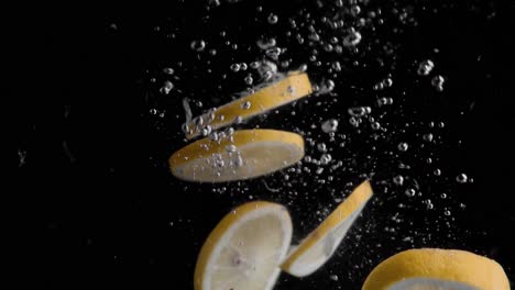 lemon slices falling into water super slowmotion, black background, lots of air bubbles, 4k240fps