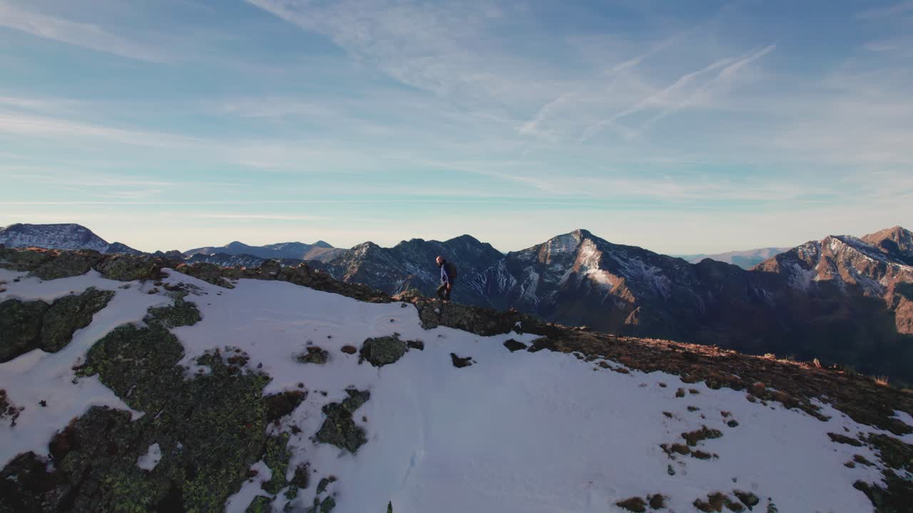 프랑스 피레네 산맥 에 있는 눈  ⁇ 인 산 꼭대기 에 오르는 남자 의 공중 촬영