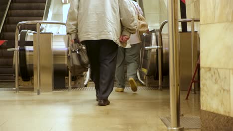 elderly people using an escalator in a subway station