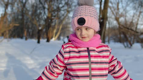 Joyful-child-kid-running,-having-fun,-dancing,-fooling-around-on-snowy-road-in-winter-park-forest