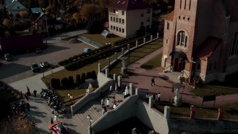 Aerial-view-of-bride-and-groom-entering-the-church-with-family