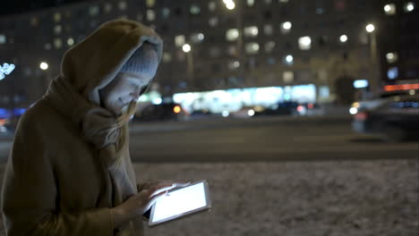 Frau-Tippt-Beim-Spaziergang-Am-Abend-Eine-Nachricht-Auf-Dem-Pad