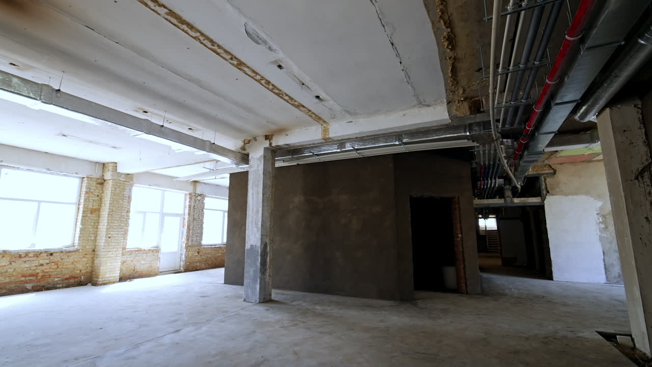 Renovating empty industrial site. Workers prepare a vacant industrial building for renovation, revealing exposed walls and plumbing