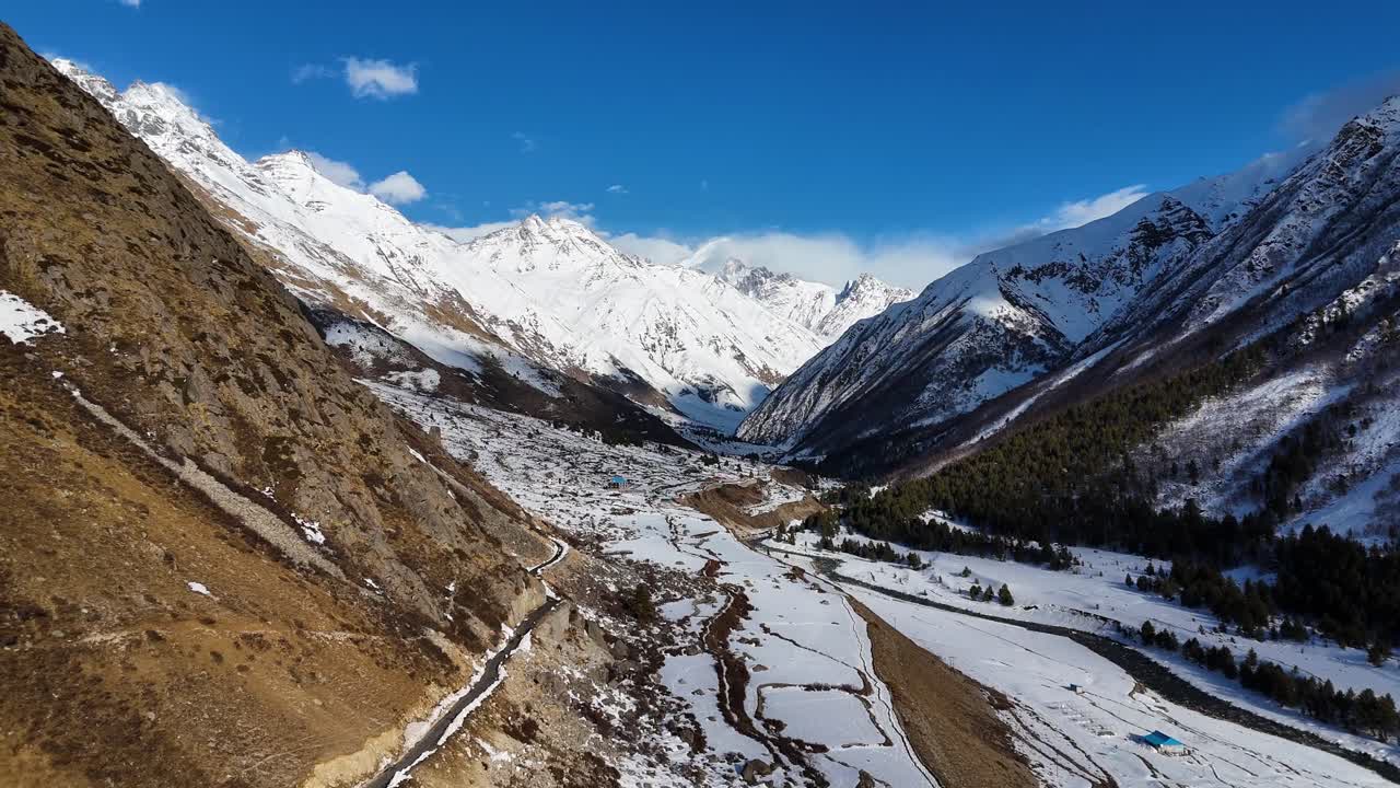una toma aérea de un avión no tripulado capturando el entorno sereno y cubierto de nieve de chitkul en himachal pradesh.