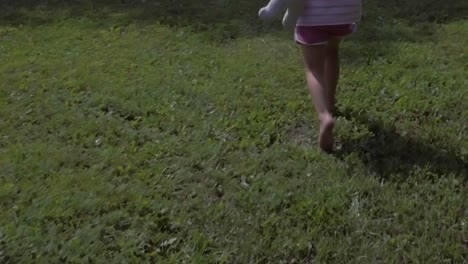 girly feet walking and running off on grass field in slow motion