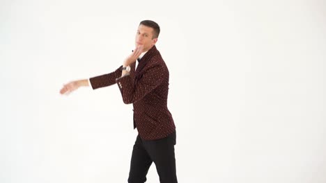 humorist in dark suit is parodying the body movements of a dancing person at a party