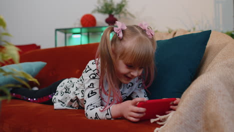 Worried-teen-child-girl-kid-enthusiastically-playing-racing-video-online-games-on-smartphone-at-home