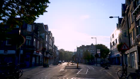 urban hyperlapse from a car in utrecht, european town, day time with pan up to sun flare, lens flare, netherlands