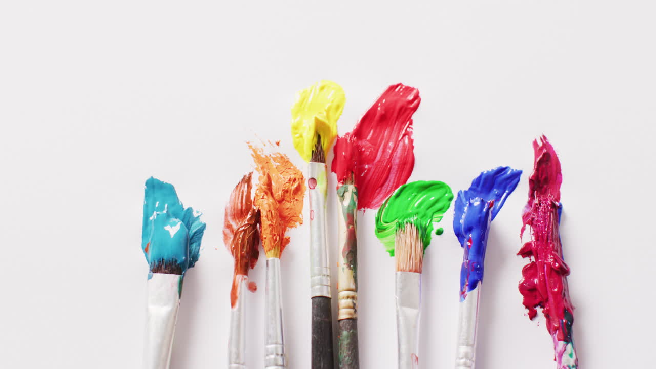 색 배경을 표시하는 페인트 브러쉬 줄에 있는 다채로운 페인트의 비디오