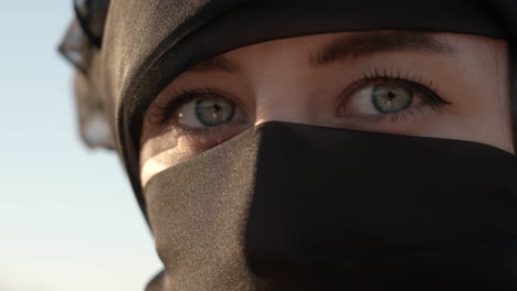 young muslim woman in hijab turning head to camera and looking with green eyes