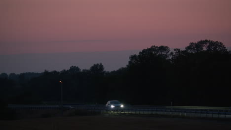 coche conduciendo en una autopista al atardecer