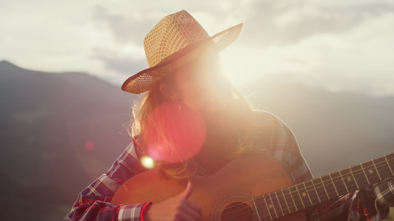 músico artístico realizar una canción de guitarra en las montañas. hermosa chica jugar de cerca.