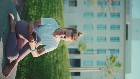 caucasian woman dressed in sportswear checking her smartphone outdoors.