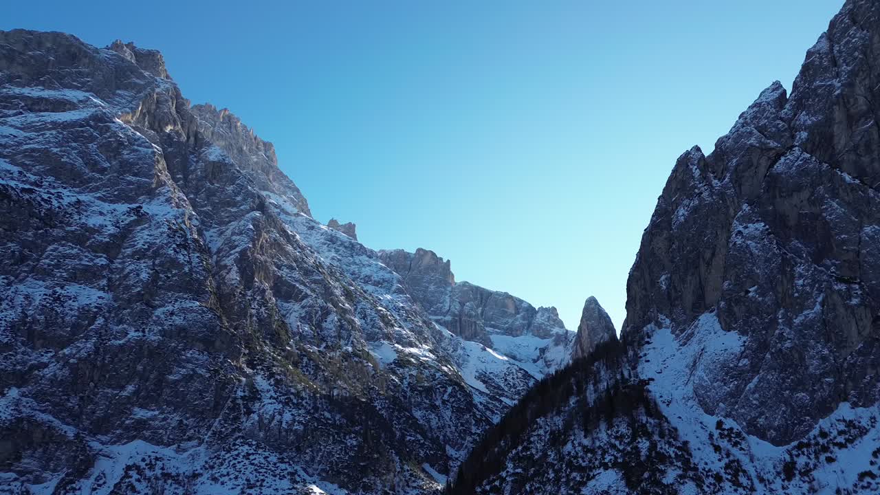 Dolomitler üzerinde karlı dağları ve canlı mavi gökyüzünü yakalayan sinematik kış drone çekim görüntüsü