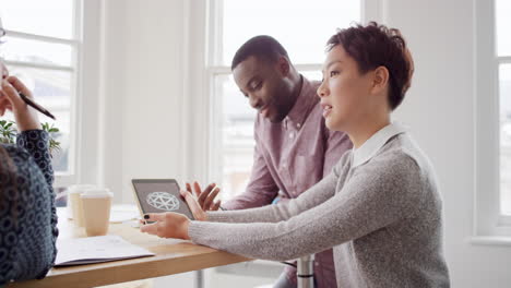 Business-woman-using-tablet-app-showing-3d-printed-model-of-geodesic-dome-walking-through-modern-office-to-diverse-team-meeting