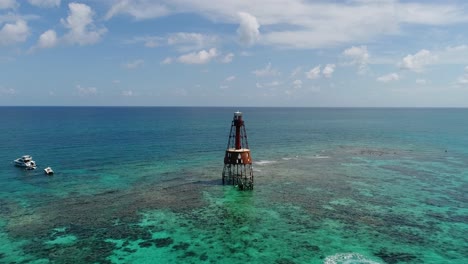 a 4k drone shot of an abandoned lighthouse, in a remote area of the caribbean sea, near bimini, bahamas