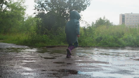 una niña saltando en un charco en un día de lluvia