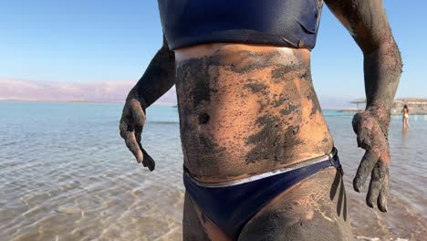 asian woman using mud in the dead sea