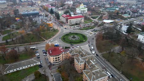 4k aerial view of roundabout road with circular cars in small european city at cloudy autumn day