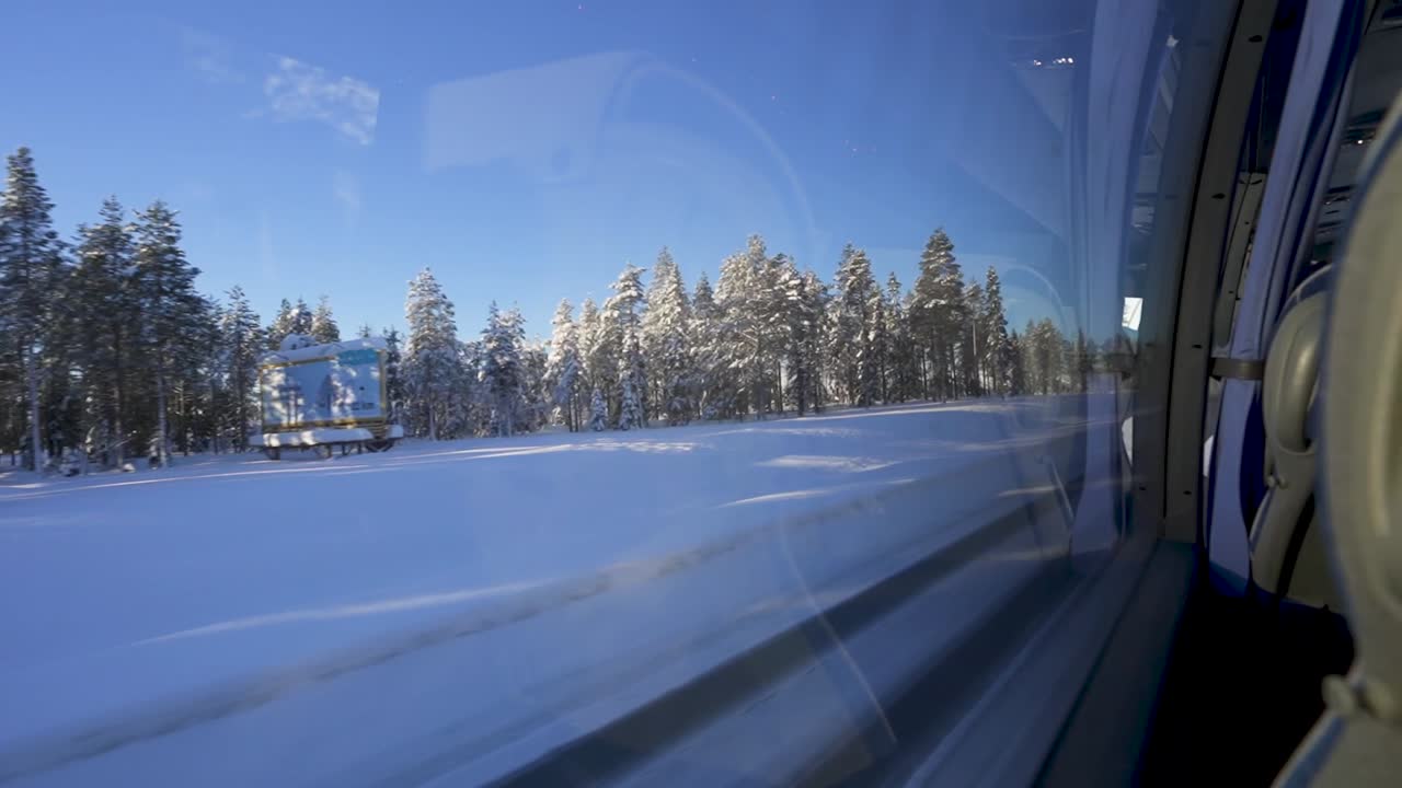 Traveling by bus down the road with snow-covered ground and trees