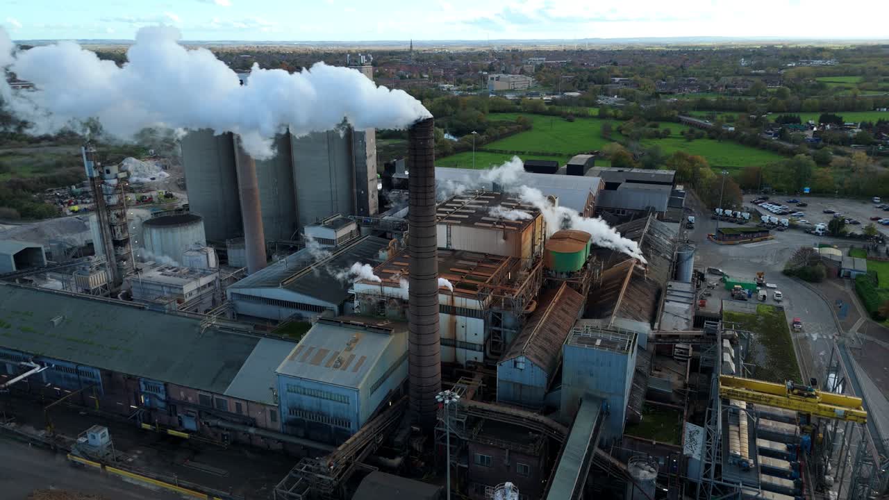 Close up aerial drone video of major sugar production industry facility with smoke plumes rising from chimneys highlighting manufacturing pollution in Newark United Kingdom