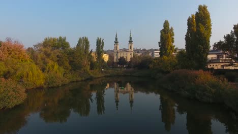 Kirchenreflexion-Auf-Dem-Wasser,-Während-Die-Drohne-Aufsteigt