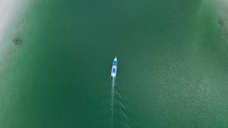 white-boat-motoring-in-crystal-clear-tropical-green