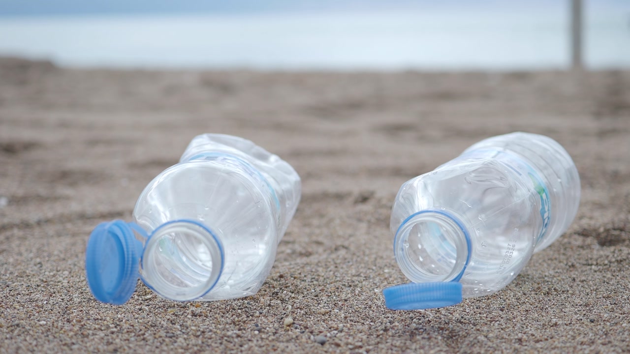 Discarded Plastic Water Bottles Polluting a Sandy Beach