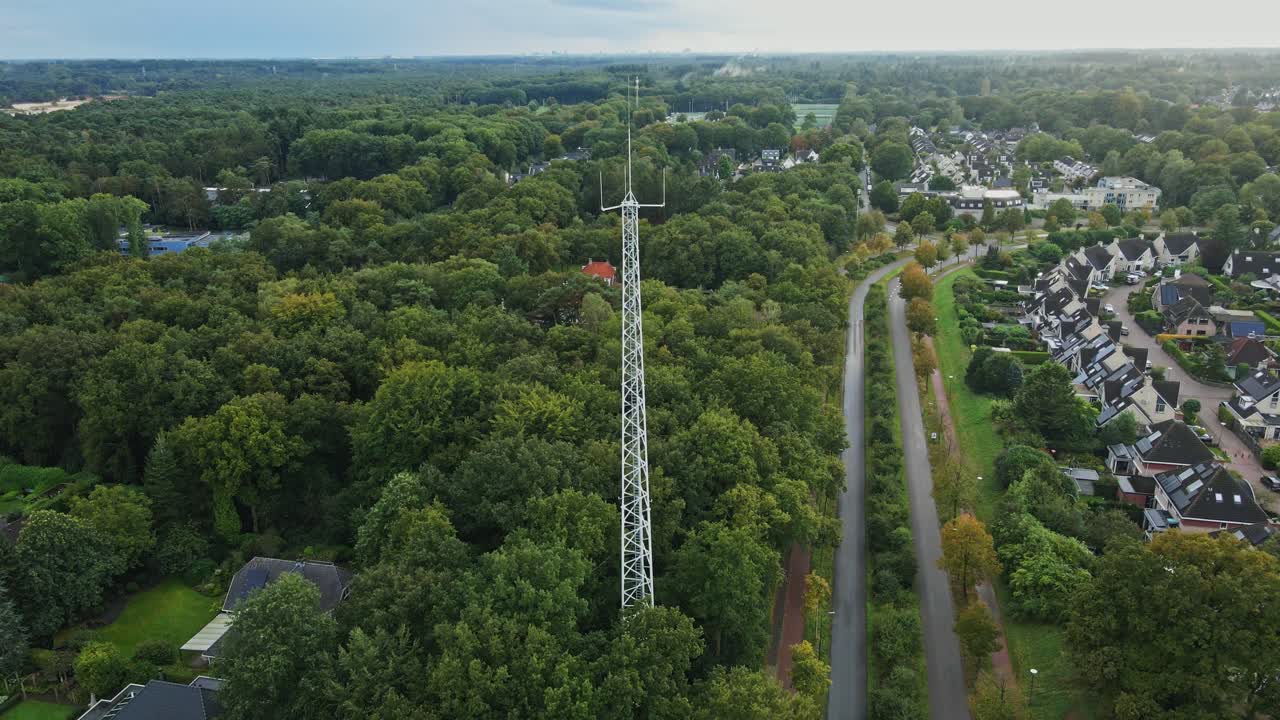 Aerial View of a Tall White Tower in a Suburban Forest