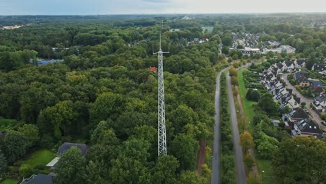 aerial view of a tall white tower in a suburban forest