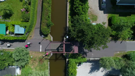 Ciclistas-Corriendo-En-La-Carretera-Que-Pasa-Por-El-Pequeño-Puente-En-Un-Día-Soleado