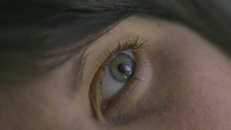 Macro-close-up-of-a-woman's-eye-as-she-opens-it-while-laying-down