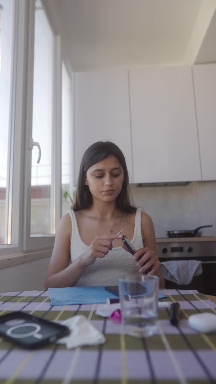 Giovane donna che pulisce un dispositivo elettronico in cucina