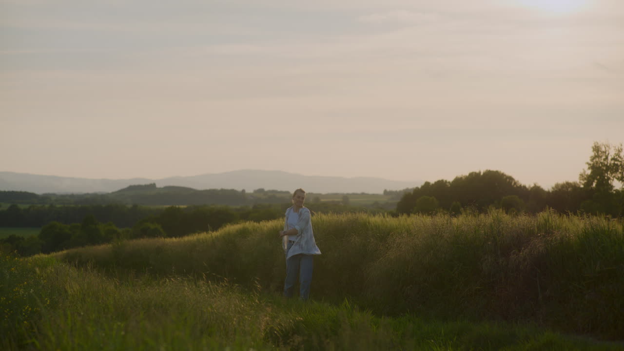 Happy Woman Enjoying Walk in Agricultural Fields at Sunset