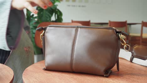 brown leather crossbody bag on a wooden table
