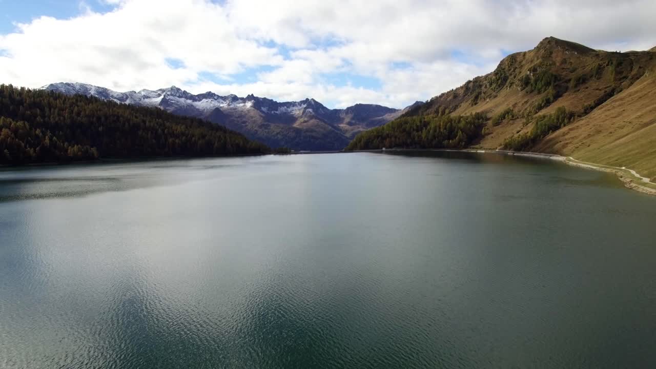 vista aérea del lago de montaña en suiza durante el otoño con montañas nevadas, revelando una toma del lago ritom