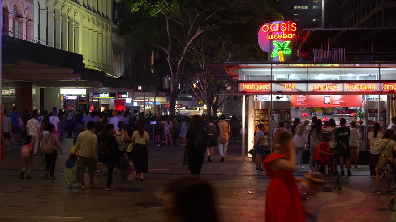 Vibrant nightlife of Brisbane city, a bustling downtown with massive crowds of people paced in Queen Street Mall after River Fire event, influx of population, fast time-lapse motion shot.