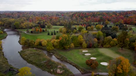 fly over a river in a park in a fall, cloudy, moody day