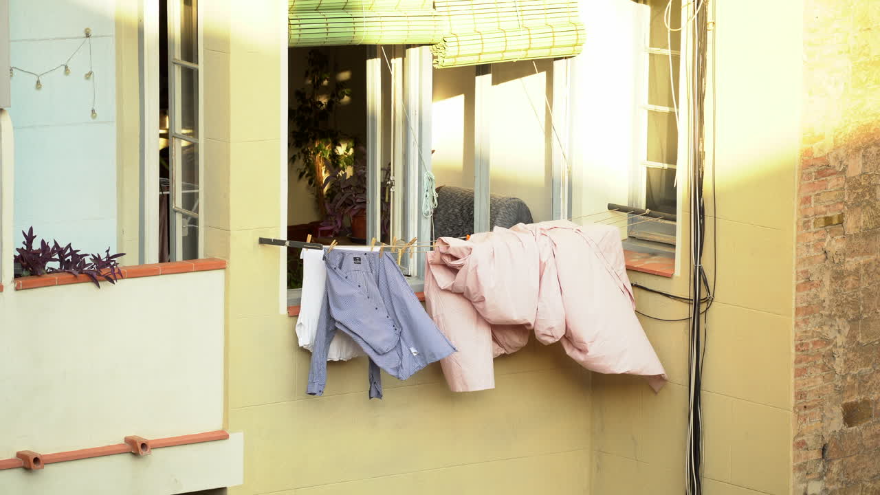 Clothes drying hanging outside window balcony, sunny day, static
