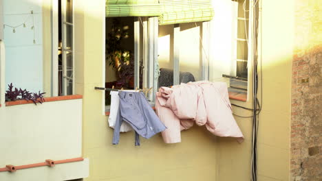 clothes drying hanging outside window balcony, sunny day, static