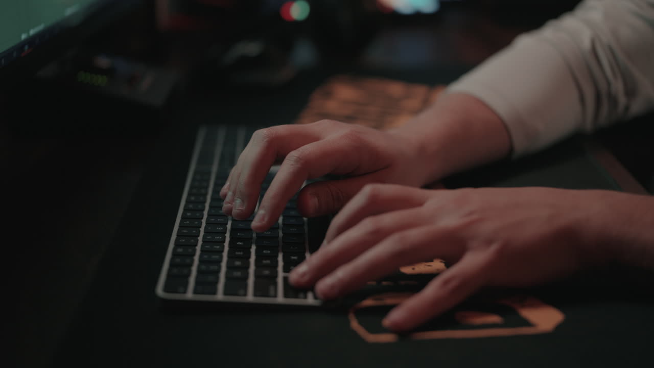 Person Typing on a Computer Keyboard at Night